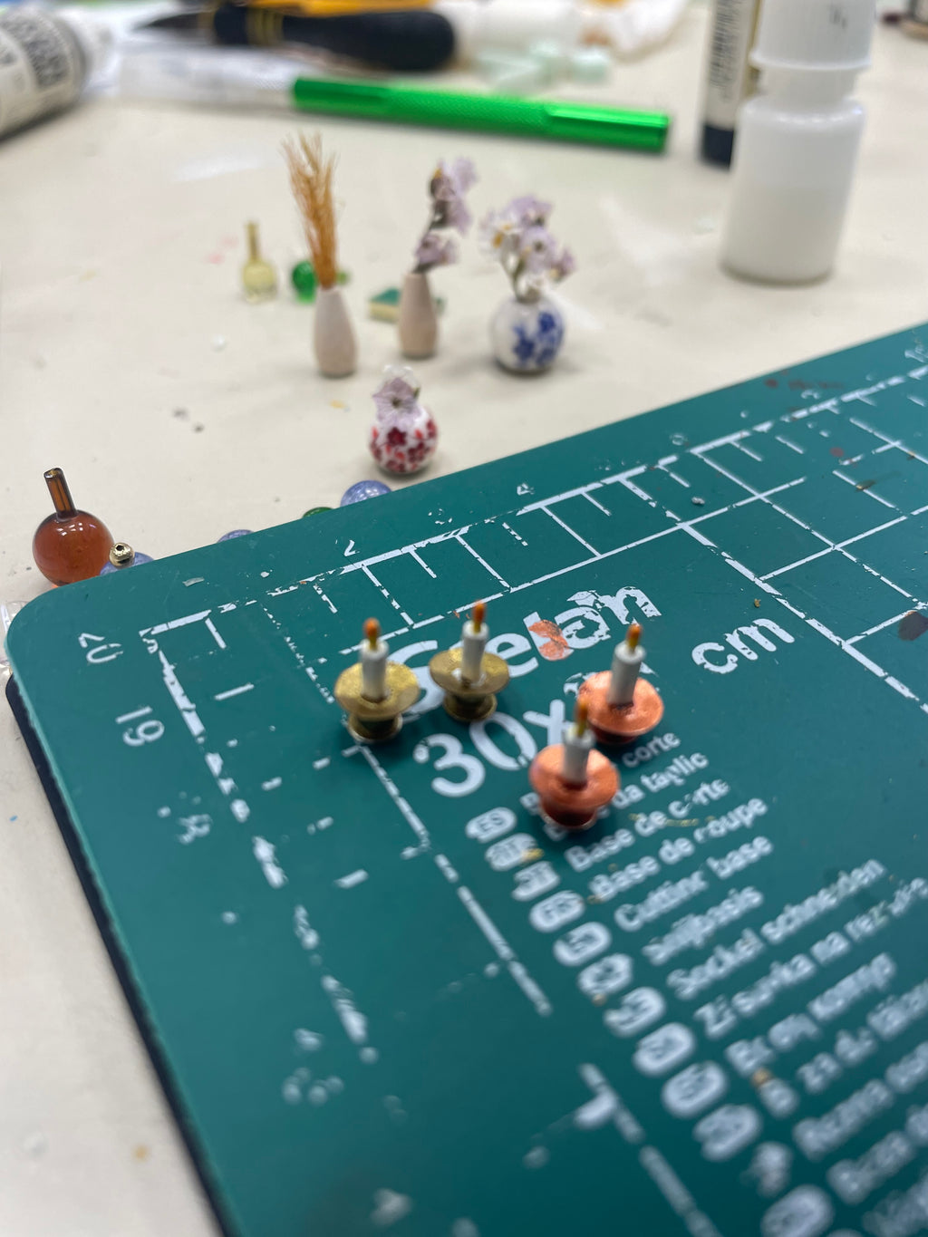 Pequeños frascos y accesorios para escenografía sobre una base de corte