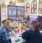 Participantes pintando miniaturas con lámparas y pinturas en el taller de Picoypincel