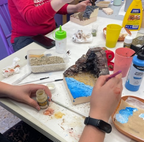 Participante trabajando en un diorama con rocas y agua azul durante un taller
