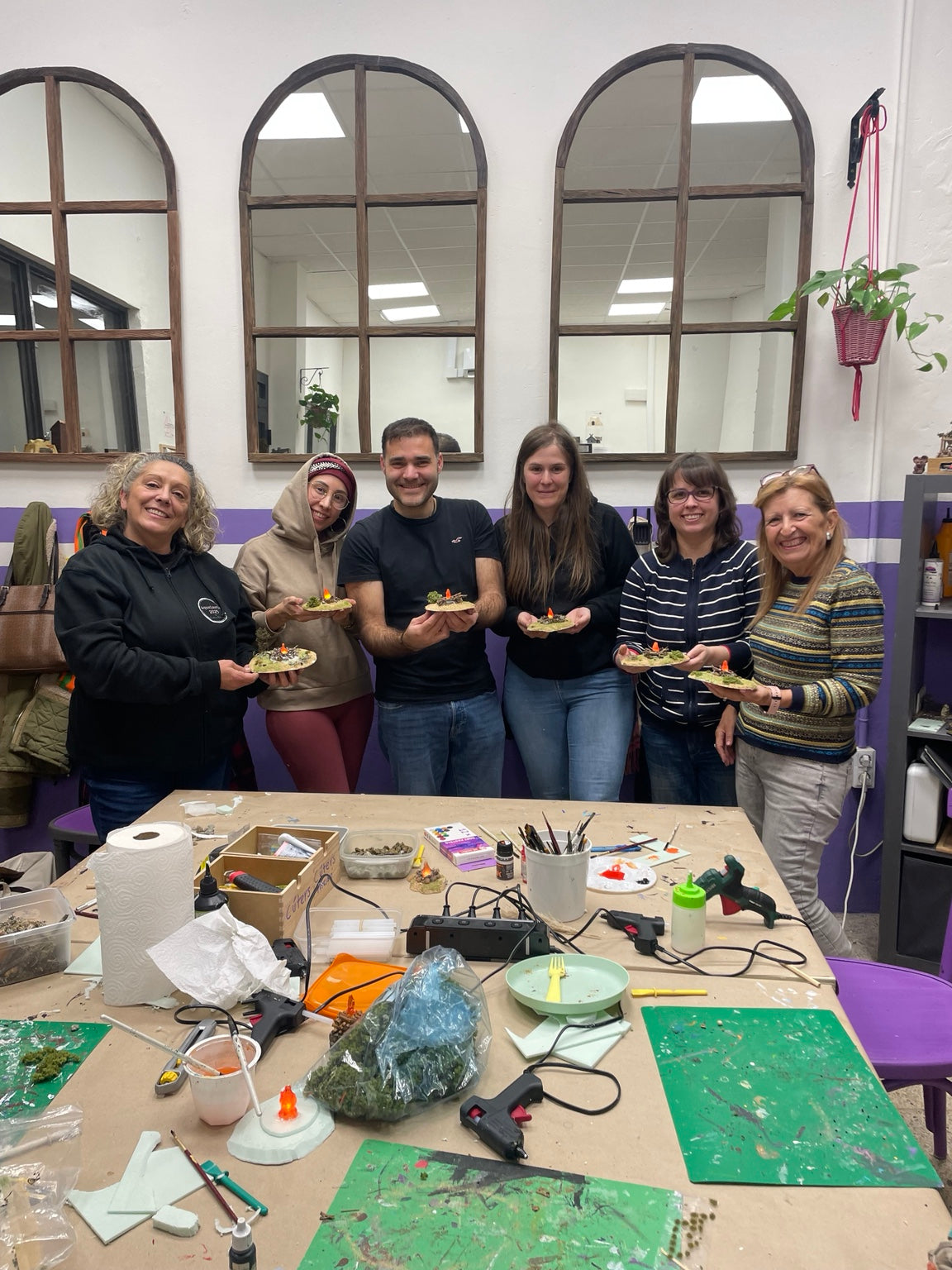Grupo de alumnos mostrando piezas realizadas en el curso de belenismo