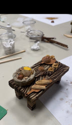 Mesa con panes y alimentos en miniatura para belenismo